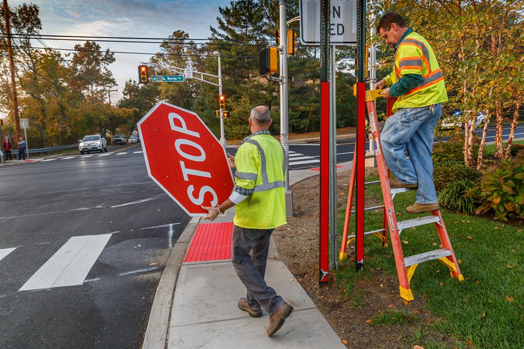 Monmouth County employees remove stop sign from intersection that now has a traffic light.
